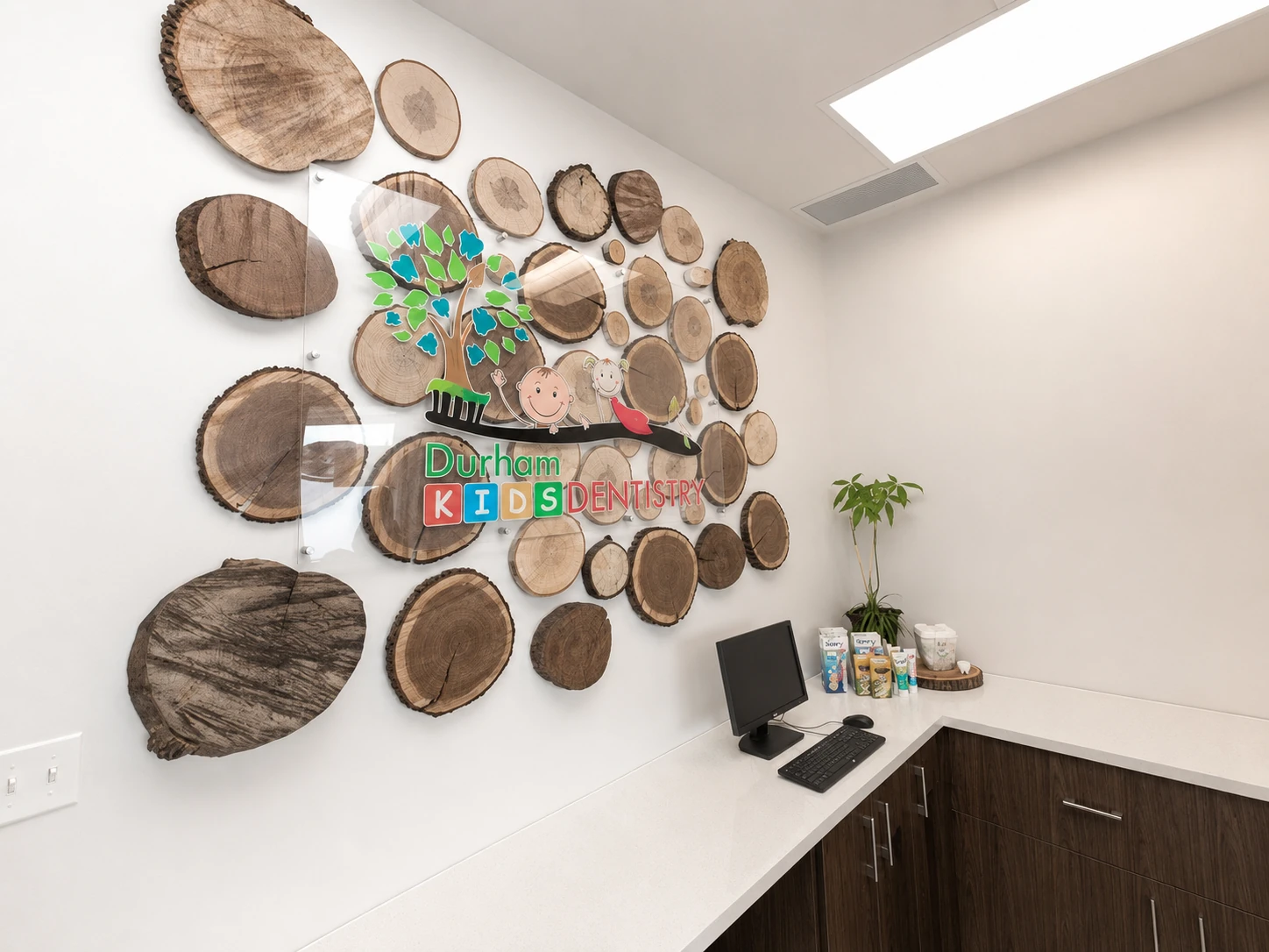 Wood-slice feature wall with the Durham Kids Dentistry logo